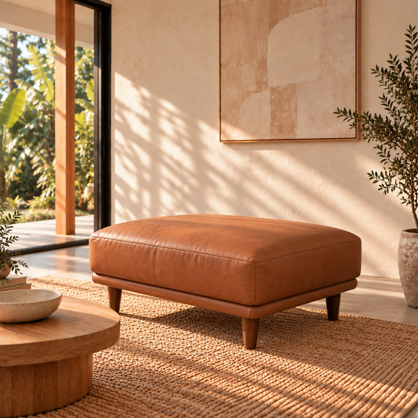 Hugo upholstered ottoman, warm tan finish, angled view in a living room